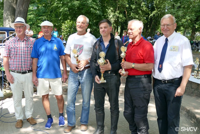 Bild: Siegerehrung im Gutspark in Mößlitz. Prämiert wurden die Gewinner der Fahrzeugklassen M1 bis M4 (Motorräder) und A1 bis A5 (Automobile). Desweiteren gab es Pokale für das Schönste Motorrad & Automobil sowie für das Schönste Kostüm und der Pechvogel.
Sie Siegerehrung nahm Fahrtleiter Ralf Zschoche, Ortsbürgermeister Jürgen Ebinger sowie Stadtbürgermeister Rolf Sonnenberger vor.