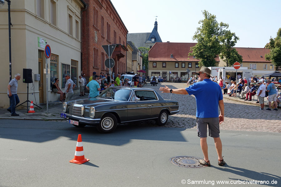 Bild: Start zur Sonntagsausfahrt vor dem Rathaus in Zörbig. Teilnehmer und Fahrzeuge werden von Fahrtleiter Ralf Zschoche und seiner Tochter Anne kurz vorgestellt.